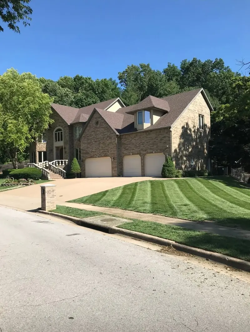 Striped sloped lawn in front of a large home