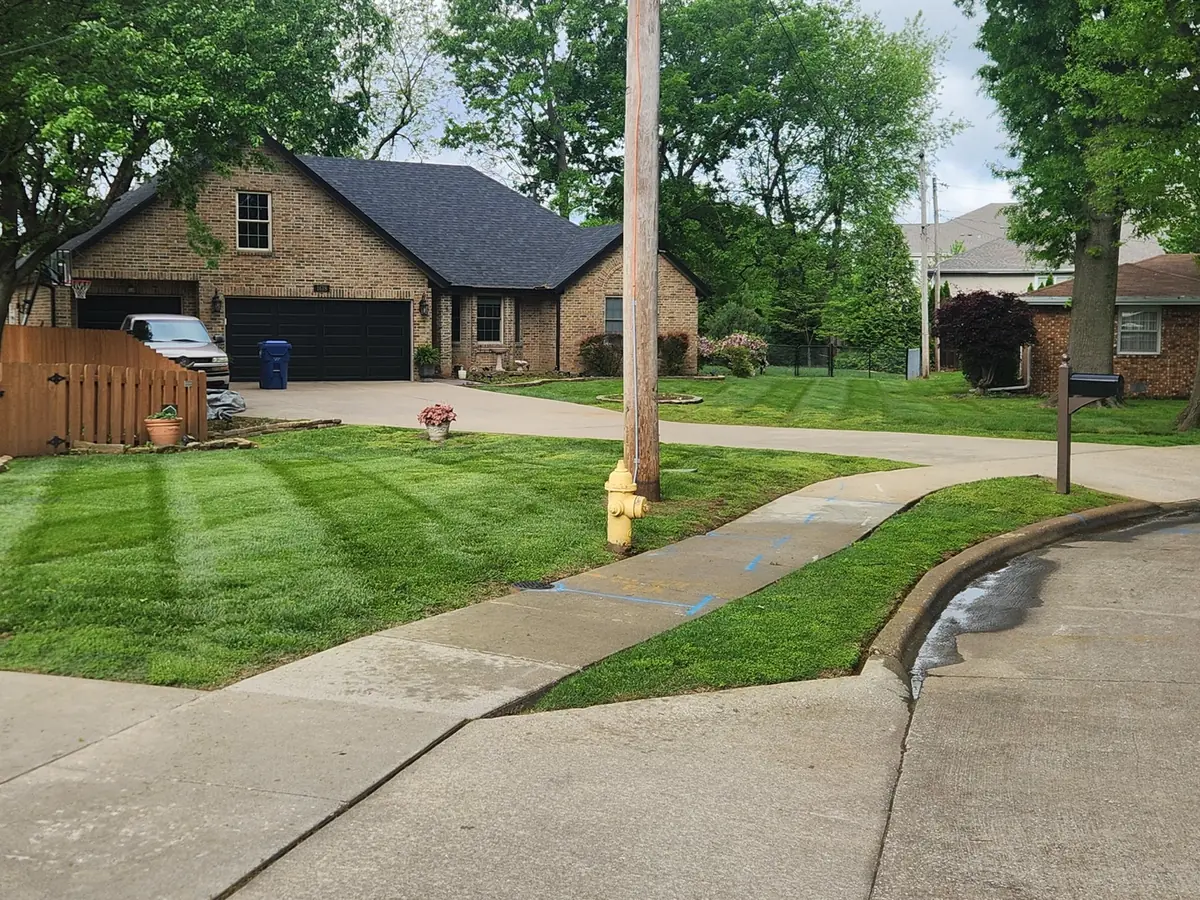 Freshly mowed front and side lawns beside a corner sidewalk