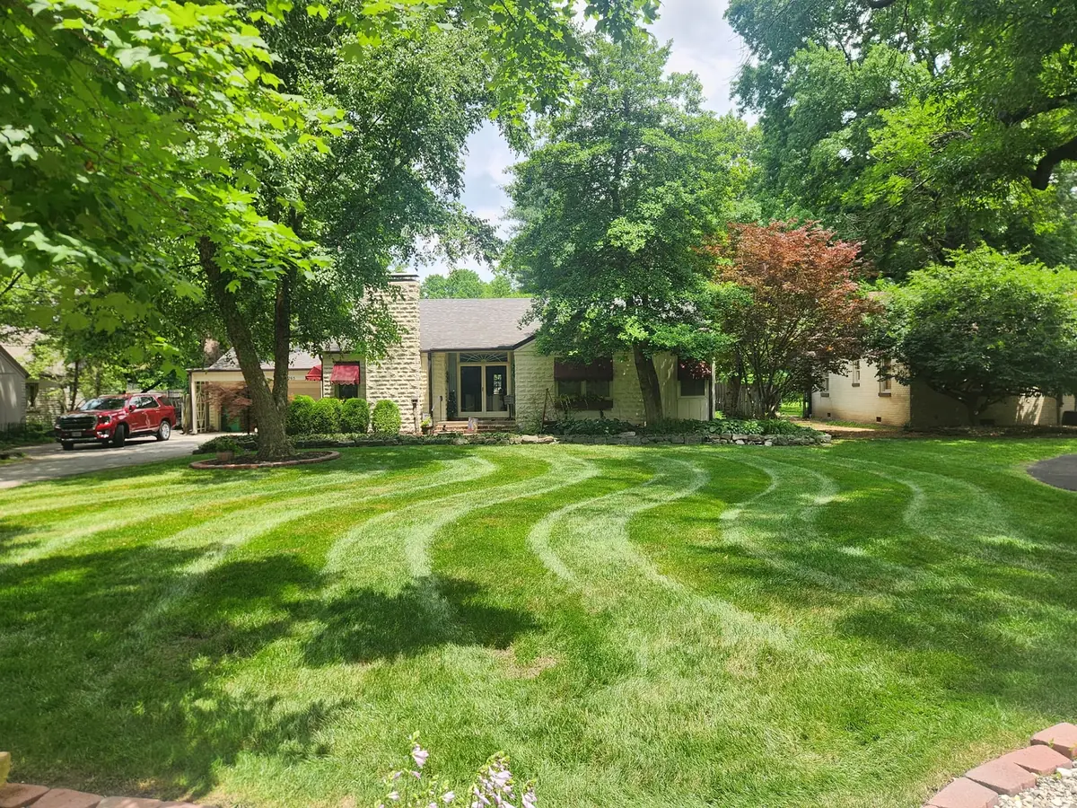 Curved mowing pattern across a shaded front lawn